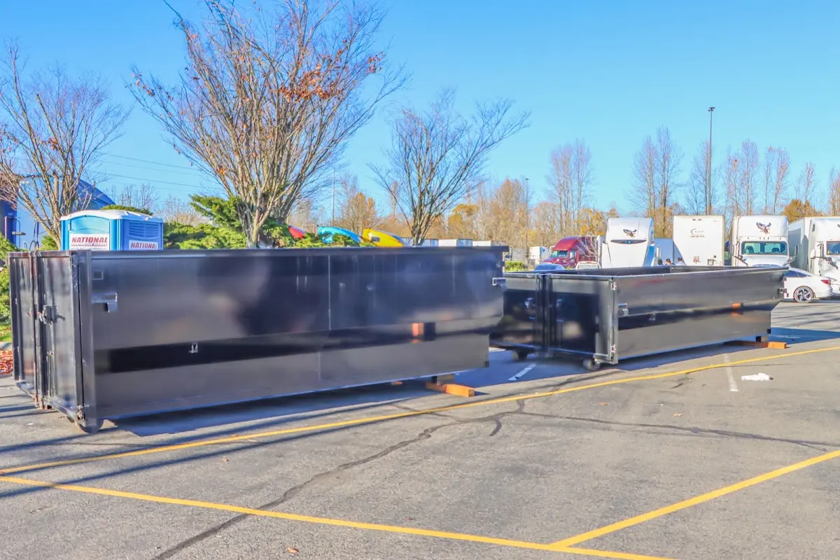 Professional dumpster rental service with roll-off container on residential driveway in Ellicott